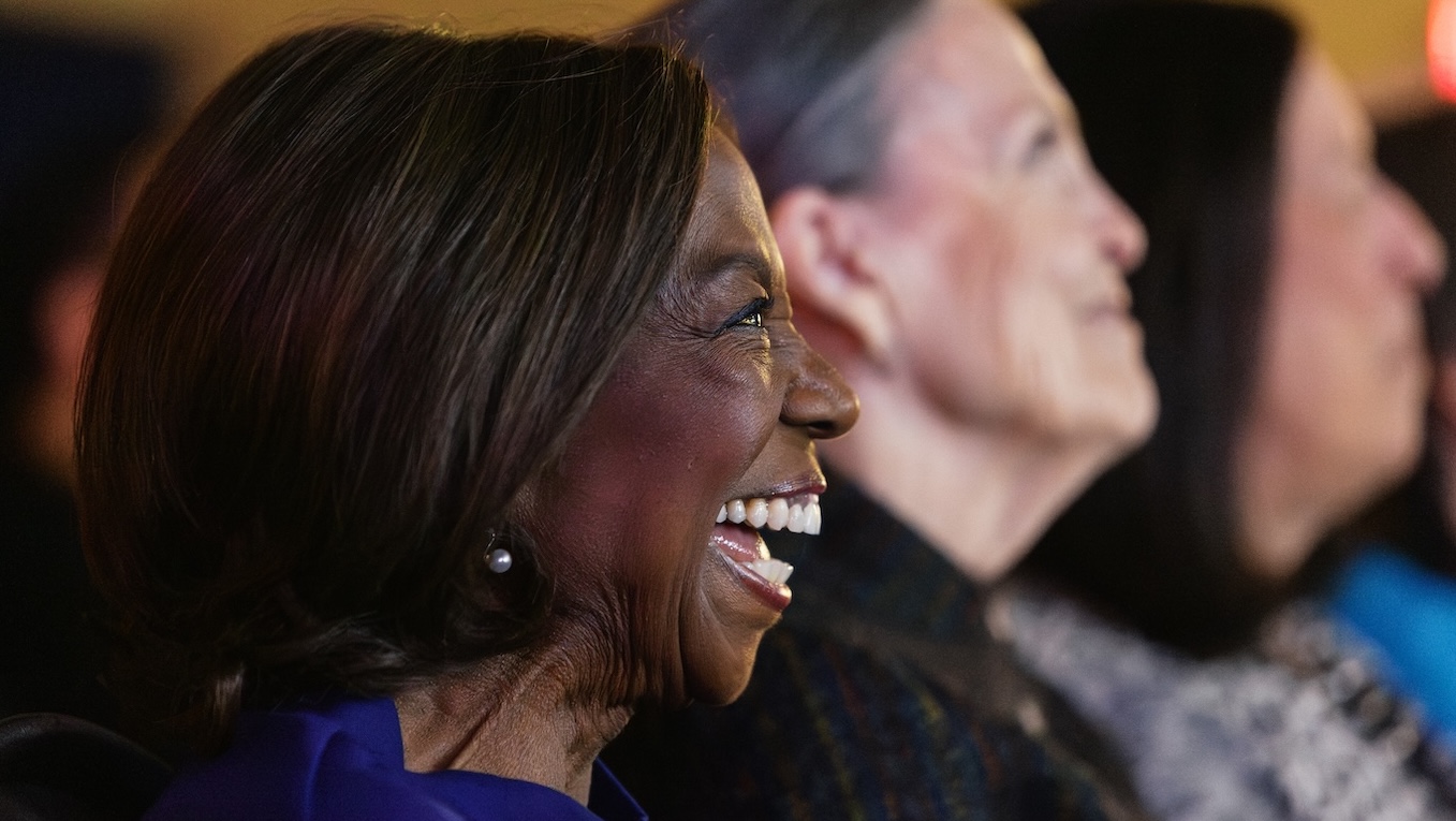 A woman laughs with happy tears in her eyes during the premiere of a documentary film that was created by UM-Dearborn students.