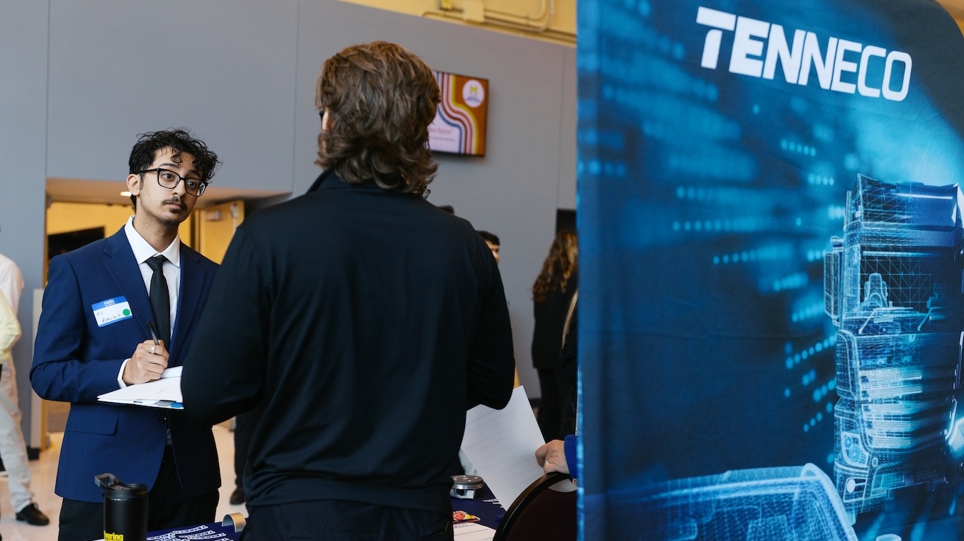 Two men talk about potentially working at the company Tenneco during a recent Career Fair on campus.
