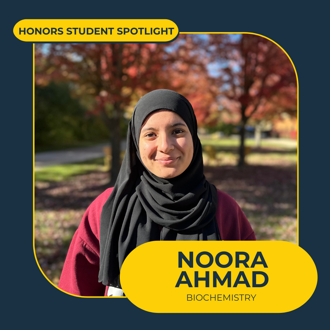 Honors student Noora Ahmad in front of fall trees