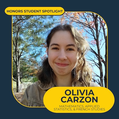 A smiling person with dark hair stands in front of a pine tree on the left and flowering/colorful leaves tree on the right with a navy blue background and text overlay in maize bubbles that reads "Honors Student Spotlight" "Olivia Carson"