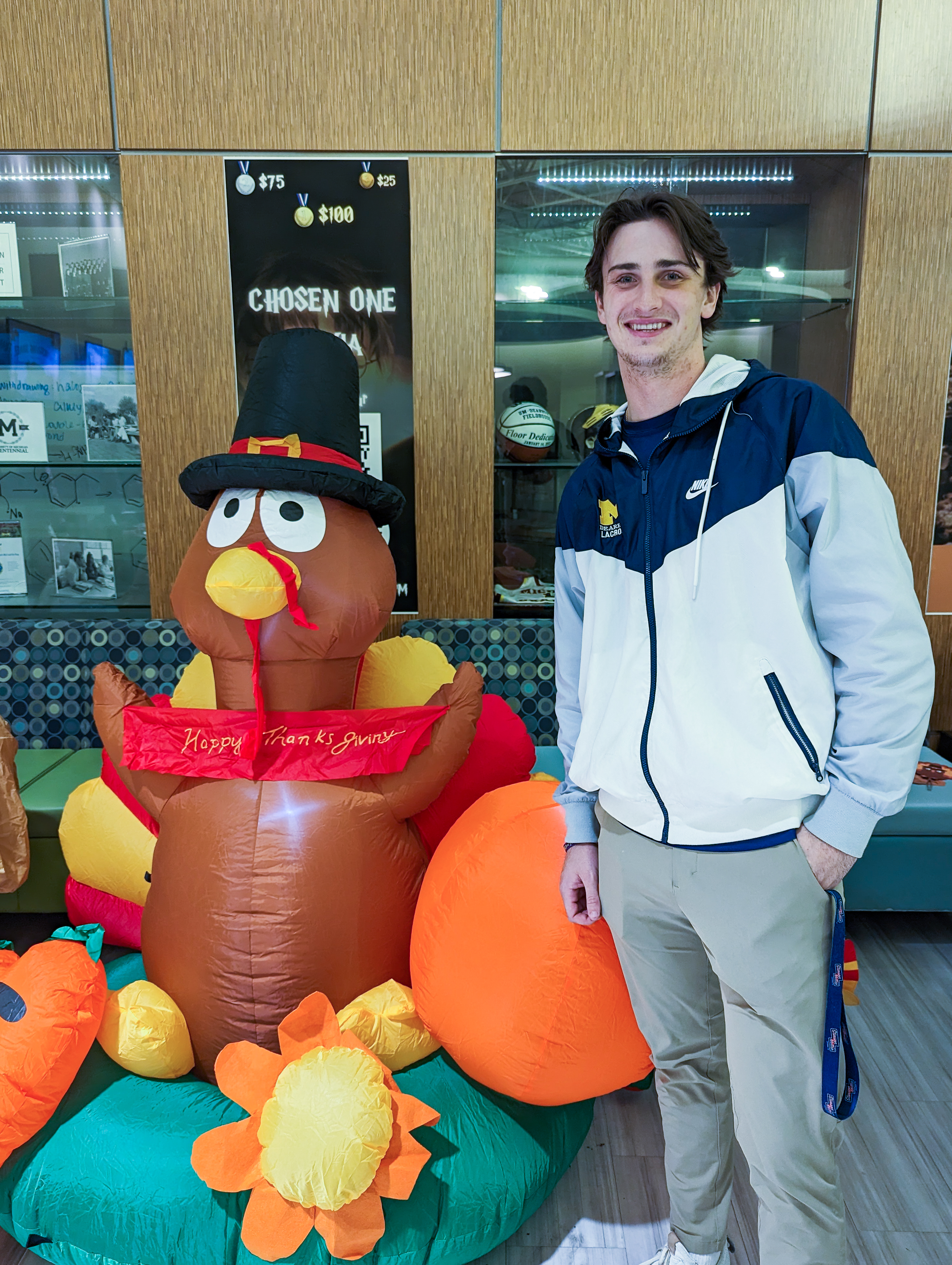 Student Joe Atherall poses near a giant inflatable turkey decoration at the 2022 UM-Dearborn Friendsgiving