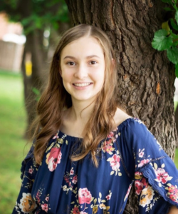 madi long blond hair outside with blue flower pattered shirt