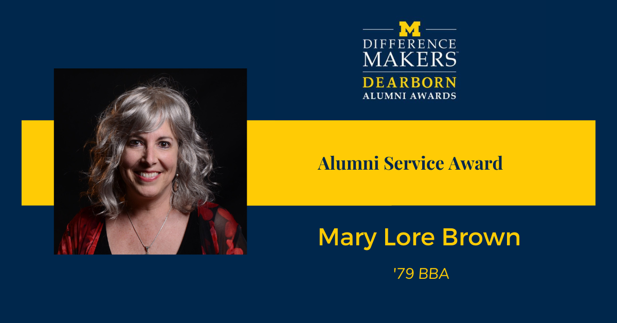 University of Michigan-Dearborn Difference Makers Alumni Awards graphic. On the left is a portrait of Mary Lore Brown with shoulder-length gray hair, wearing a black top and a red patterned shawl. On the right, the text reads: 'Alumni Service Award – Mary Lore Brown, ’79 BBA.'