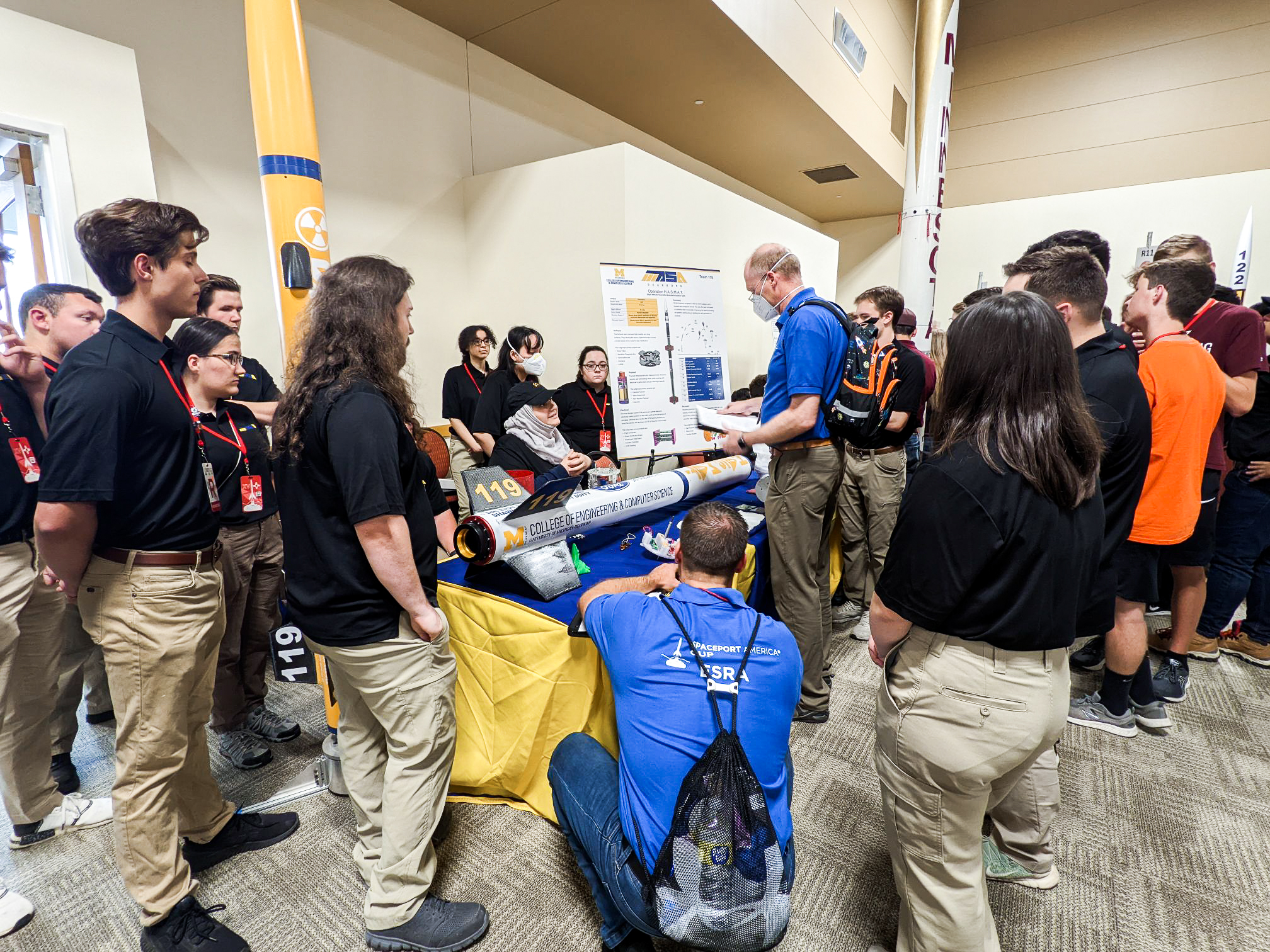Members of the UM-Dearborn rocket team show off their rocket at a poster session at the 2022 Spaceport America Cup.