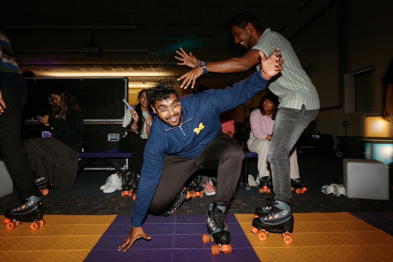 Students wear roller skates and try not to fall during a roller skating event.