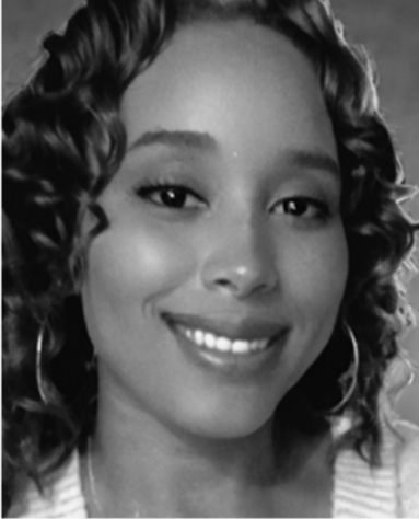 A black-and-white portrait of a woman with shoulder-length curly hair, smiling softly at the camera. She is wearing hoop earrings and a light-colored top.