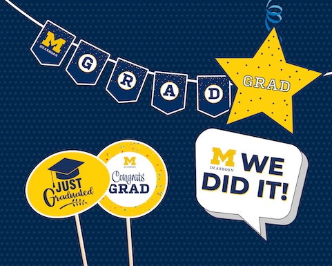 University of Michigan-Dearborn graduation decorations with banners, a yellow star, and signs reading “Just Graduated,” “Congrats Grad,” and “We Did It!”