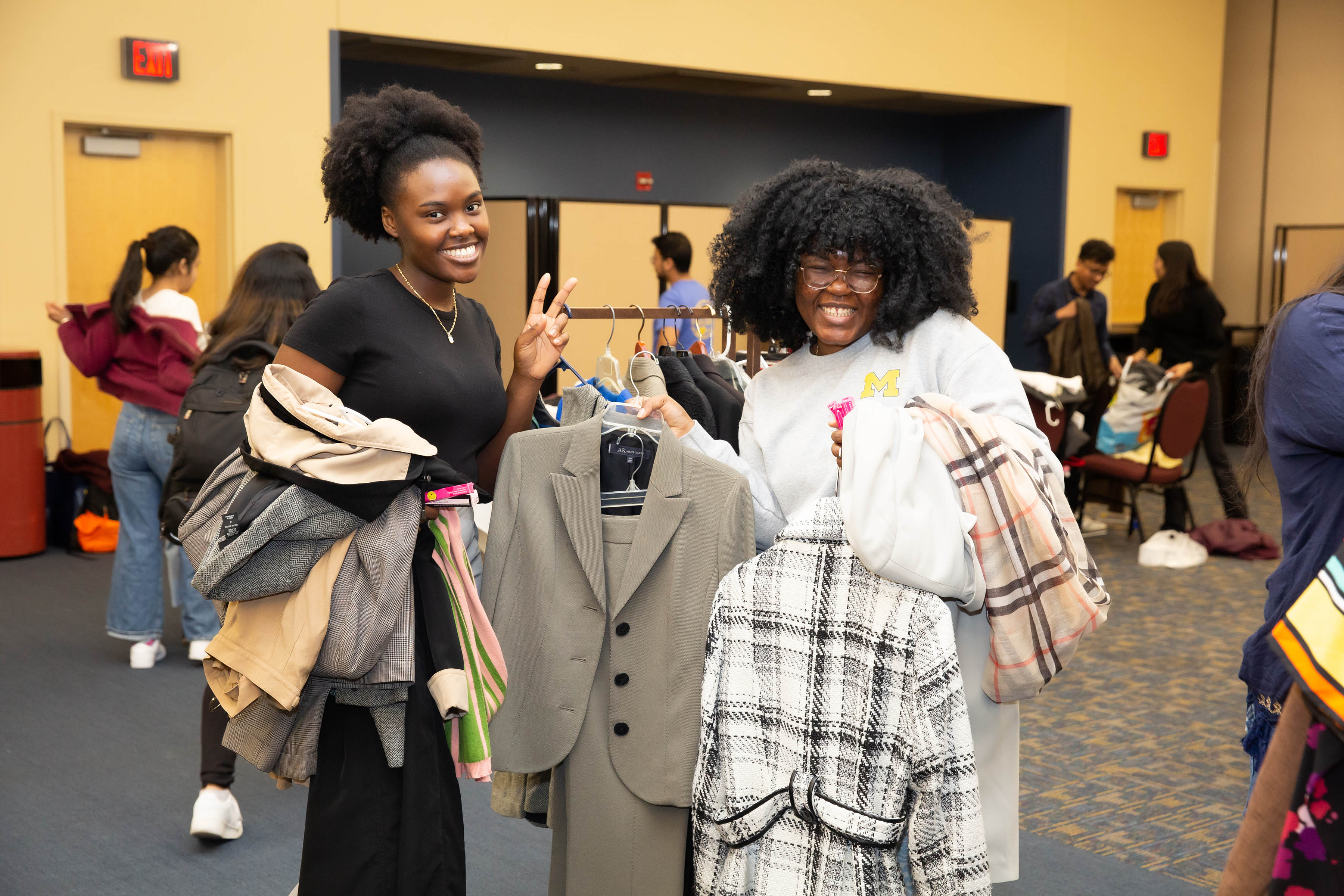 Two students pose for a photo with new clothing they've picked out at the clothing pantry pop-up event.