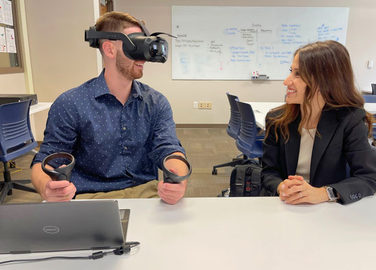 Students working together with a VR headset.