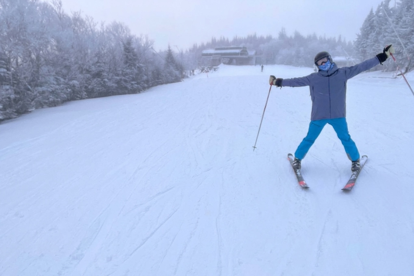 A person skiing with their hands in the air.
