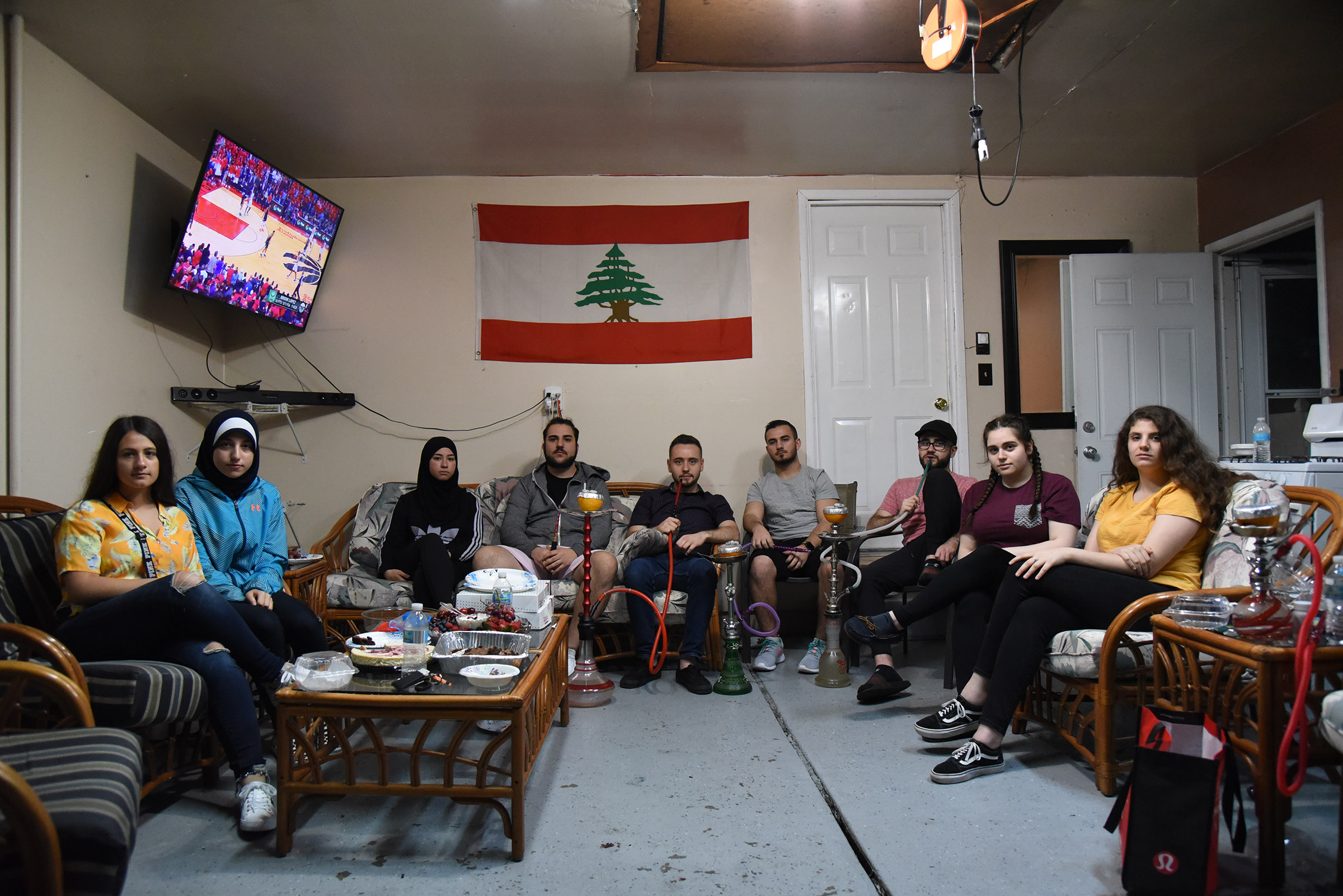 Young people in Dearborn gather in a garage, which has been furnished with comfortable furniture, a coffee table and a TV on the wall