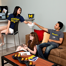 Students in a living room in their housing unit