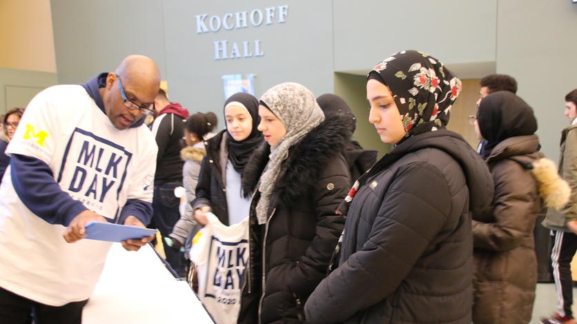 Students read quotes from Dr. Martin Luther King Jr. while waiting in line to check in during the MLK Day of Service.