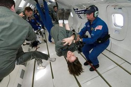 Samantha Snabes somersaults weightlessly in the Vomit Comet, alongside other students and a professional from NASA.