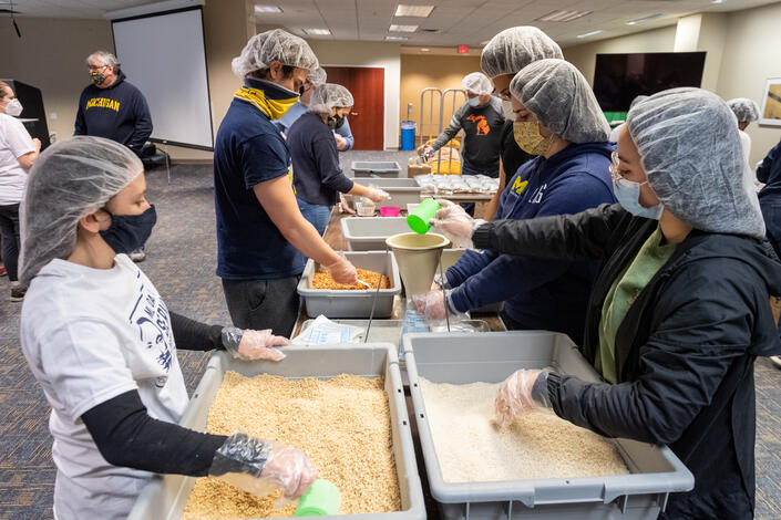 Students pack meal kits in Fairlane Center North for the Kids Coalition Against Hunger. Photo by Scott Soderberg