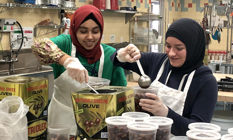 Volunteers divide bulk food items for the pantry at Zaman International