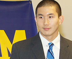 Brent Noh, a student at U-M’s Ross School of Business, standing in front of M background