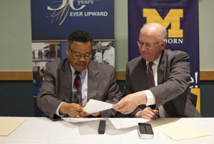 Conway A. Jeffress, president , Schoolcraft College and Daniel Little, chancellor, UM-Dearborn sign the reverse transfer agreement. 