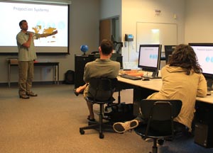 Professor teaching students in UM-Dearborn’s Geographic Analysis and Mapping (GAM) lab