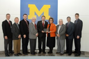 Representatives from University of Michigan-Dearborn congratulate the City of Sturgis, Mich., for the city's commitment to business development standing in front of a UM-Dearborn flag.