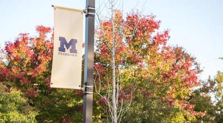 UM-Dearborn banner in front of autumn trees