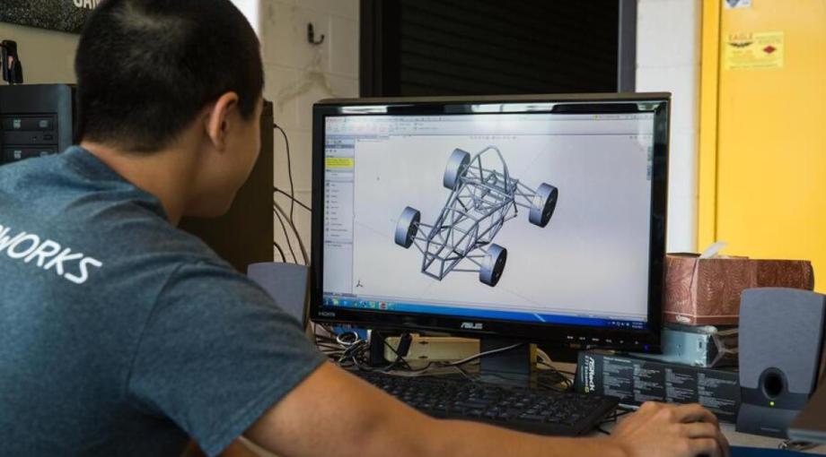 Student looking a CAD drawing on computer screen.