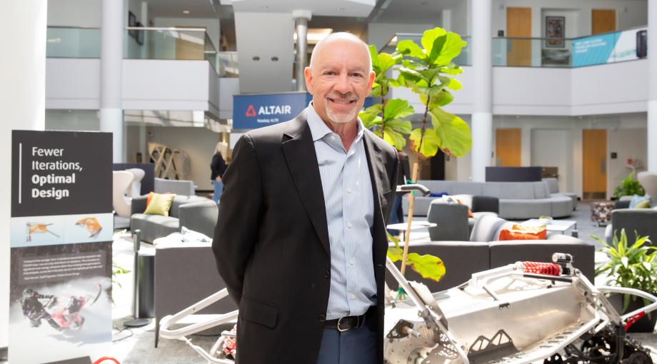 Jim Scapa stands for a portrait in the brightly lit lobby of his technology company Altair.