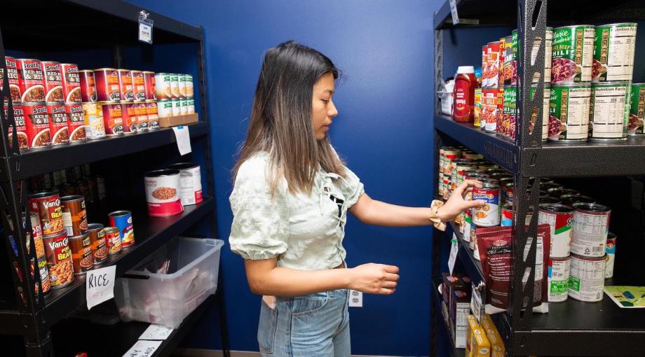 A student stocks shelves at the UM-Dearborn Student Food Pantry