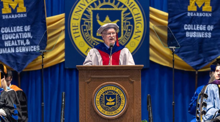 In full academic regalia, Tony England, dean of the College of Engineering and Computer Science at UM-Dearborn, gives a commencement address in 2019.