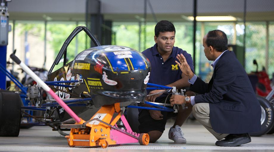 Student and instructor inspecting SAE car