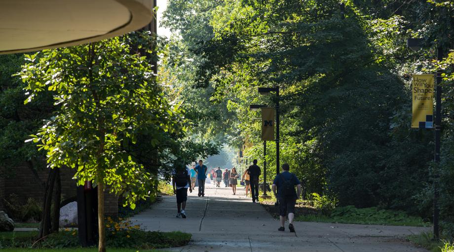 Students walking across campus on summer day.
