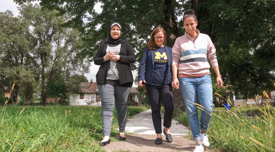 Assistant Professor OF Public Health Natalie Sampson (center) walks with senior Valeria Cossyleon (right) and Janine Hussein (‘18), two UM-Dearborn students who helped collect door-to-door health surveys. 