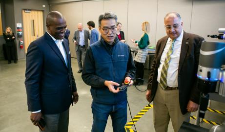 Omron Corporation’s Tim Hill (left) checks out one of the new robotic arms with Assistant Professor of Electrical and Computer Engineering Jaerock Kwon and CECS Dean Ghassan Kridli (right). 