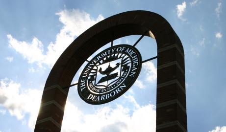 Looking upward toward brick arch containing the university seal on the UM-Dearborn campus on a sunny day