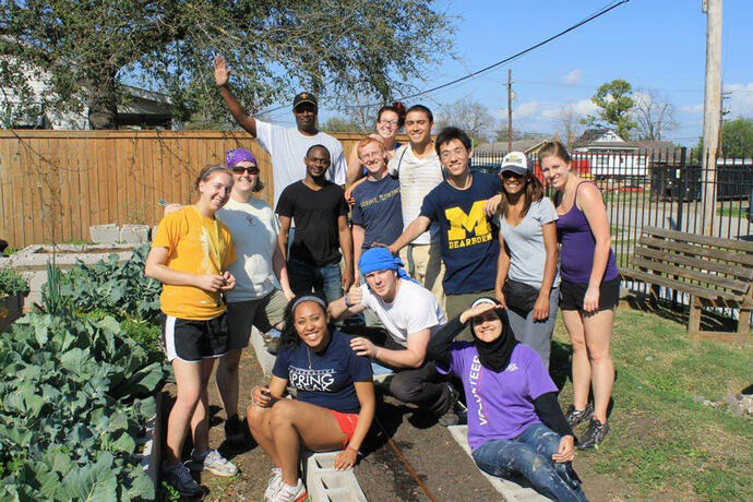 A group of students volunteering at a community garden