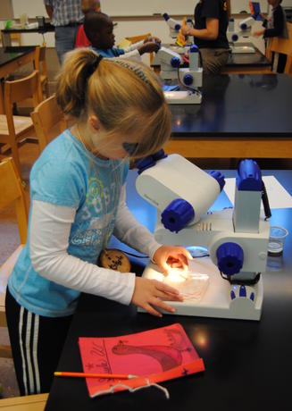 Young Naturalist Program participant using a microscope