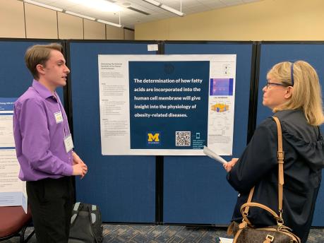Blake Hardin shares his research poster with librarian Joan Martin