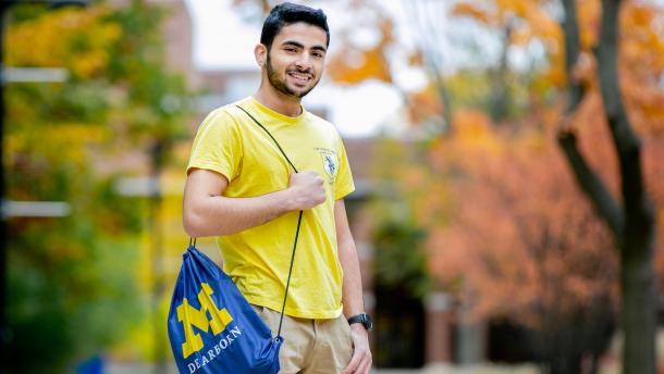 Male student on campus with UM-Dearborn bag.