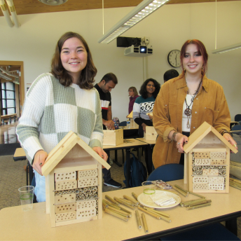 two people holding insect hotels