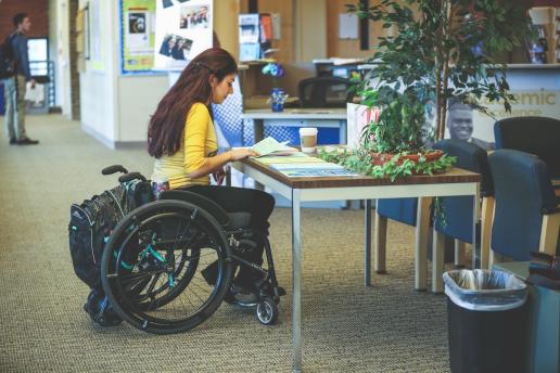 Student working at desk in her wheelchair