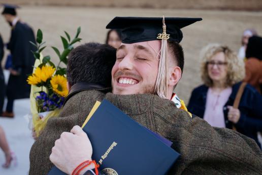 A proud male graduate hugging 