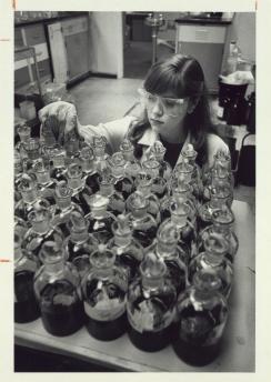 Historic black and white photo of female student in lab