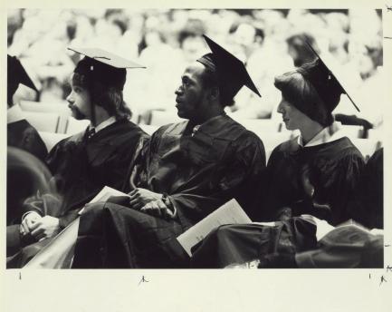 Black and white photo of students in cap and gown at commencement.