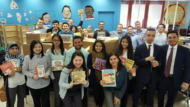 Group of students all holding up a children's book
