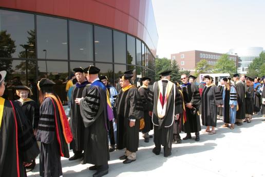 Faculty dressed in academic attire in lining up for procession