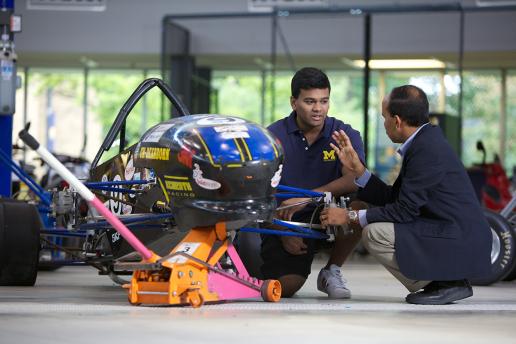Student and instructor inspecting SAE car