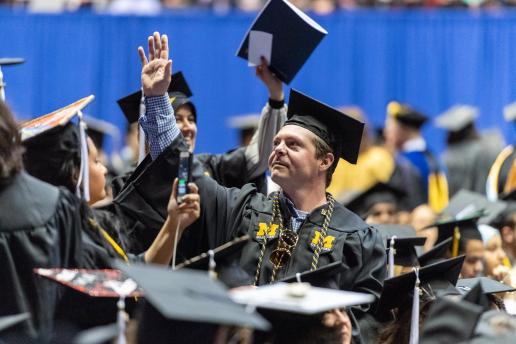 A male student waiving during Graduation ceremony.