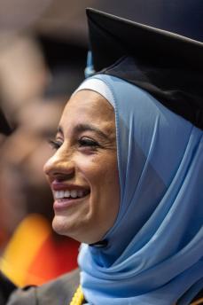 Smiling woman wearing hijab and graduation cap