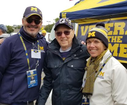 3 people outdoors dressed in Michigan clothing