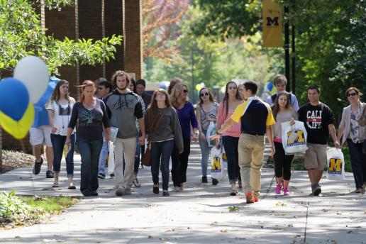 Student leading campus tour of group of students and parents